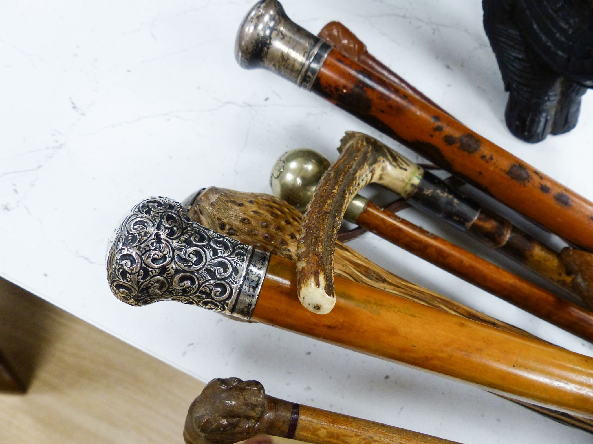 Three silver mounted canes, carved crops and tipstaffs